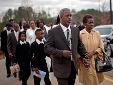 In this Wednesday, Nov. 30, 2011 file photo, Robert Champion Sr., left, and his wife, Pam lead a procession into the funeral service for their son, Florida A&M University band member Robert Champion, in Decatur, Ga. (AP Photo/David Goldman)