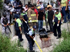 Police remove from a canal plastic bags containing the dismembered bodies of four people in Boca del Rio, Mexico, on Thursday, May 3, 2012. The bodies were found dumped together in plastic bags by a canal in the eastern Mexican state of Veracruz on Thursday, less than a week after the killing of a reporter for an investigative newsmagazine. At least three of the slain had worked as news photographers. (AP Photo/Felix Marquez)