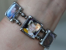 Tara McDonald, mother of slain Victoria (Tori) Stafford, shows her new bracelet with photos of Tori as she enters the courthouse at the Michael Rafferty murder trial in London, Ont., Friday, May 11, 2012. (THE CANADIAN PRESS/Dave Chidley)