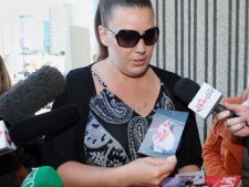 Tara McDonald, mother of slain Victoria (Tori) Stafford, shows photos of Tori outside the courthouse at the Michael Rafferty murder trial in London, Ont., Friday, May 11, 2012.  (THE CANADIAN PRESS/Dave Chidley)