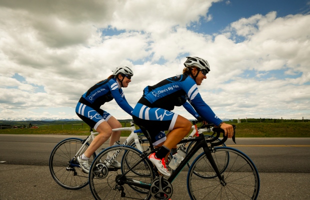 Clara Hughes, left, a multiple Olympic medalist, rides her bike near Millarville, Alta., Friday, May 30, 2014. Hughes is on a tour across Canada to raise awareness about mental health and help end the stigma around mental illness. THE CANADIAN PRESS/Jeff McIntosh
