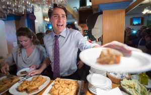 Liberal Leader Justin Trudeau and his wife Sophie serve baklavas to supporters during a campaign stop at a Greek restaurant Thursday, Oct. 15, 2015 in Laval, Que. (The Canadian Press/Paul Chiasson)
