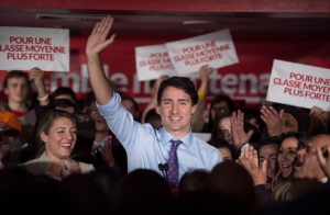Liberal leader Justin Trudeau salutes the crowd flanked by local candidate Melanie Joly during a campaign event Thursday, October 15, 2015 in Montreal. THE CANADIAN PRESS/Paul Chiasson