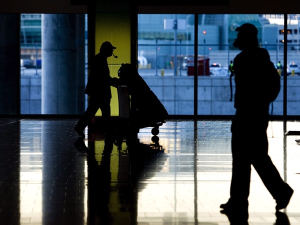 People are silhouetted as they make their way through Pearson International Airport in Toronto, on Thursday, Sept. 18, 2008. (Nathan Denette / THE CANADIAN PRESS)