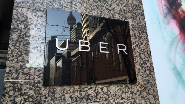 The CN Tower is reflected in an Uber sign outside the company's office on Adelaide Street in downtown Toronto. (Joshua Freeman /CP24)