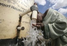 A young boy prepares to drink clean water from a borehole in Harare, Thursday, Dec. 11, 2008. (AP / Tsvangirayi Mukwazhi)