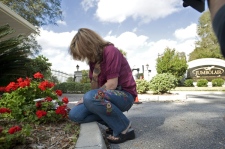 Diana McCarty of Citra, Fla., bows her head after laying a rose at the entrance to the Jumbolair Aviation Estates where actor John Travolta lives, Tuesday, Jan. 6, 2009 near Ocala, Fla. (AP / Phil Sandlin)