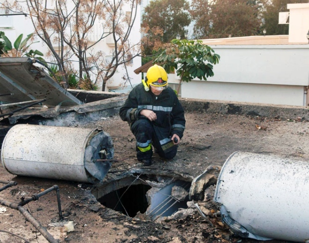 An Israeli firefighter looks at the damage made after a rocket fired from Lebanon hit a building in the northern Israeli coastal town of Nahariya, Thursday Jan. 8, 2009. (AP / Yaron Kaminsky)