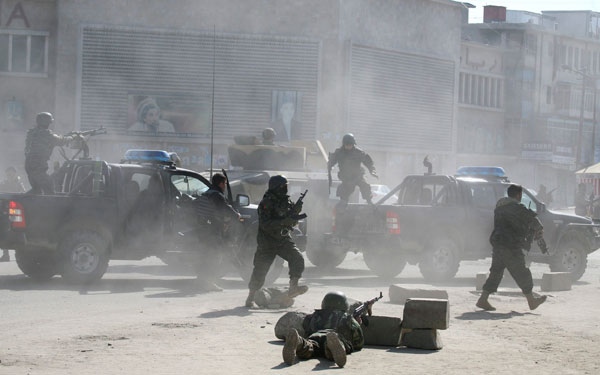 Afghan security forces run for the site of Afghan Justice Ministry following an attack in Kabul, Afghanistan on Wednesday, Feb. 11, 2009. (AP / Musadeq Sadeq)