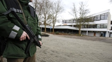 An armed police officer stands in front of the Albertville school in Winnenden near Stuttgart, Germany, Wednesday, March 11, 2009. (AP / Thomas Kienzle)