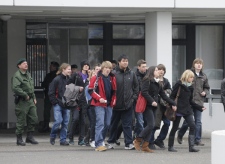 A police officer escorts pupils leaving an elementary school nearby the Albertville school in Winnenden, near Stuttgart, Germany, Wednesday, March 11, 2009. (AP / Daniel Maurer)