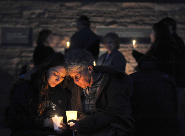Elizabeth Hickman, right, hugs her daughter Maggie Hickman, left, both of Tennessee, at a candlelight vigil at the Columbine Memorial at Clement Park near Littleton, Colo. on Sunday, April 19, 2009. (AP / Chris Schneider)