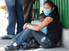 An unidentified woman wears a protective mask while waiting outside of the emergency room at Hospital Ruben Lenero in Mexico City, on Saturday, April 25, 2009. Mexico is struggling with a new strain of swine flu that has killed 68 and sickened more than 1,000. (AP / Houston Chronicle, Julio Cortez)