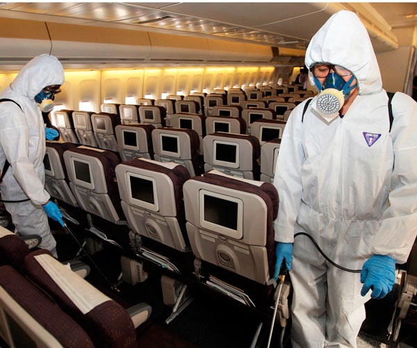 South Korean quarantine officers disinfect inside a Korea Air Line jetliner from Chicago against the possible infection of the swine flu at Incheon International Airport in Incheon, west of Seoul, South Korea, Monday, May 4, 2009. (AP / Yonhap, Lee Jung-hun)