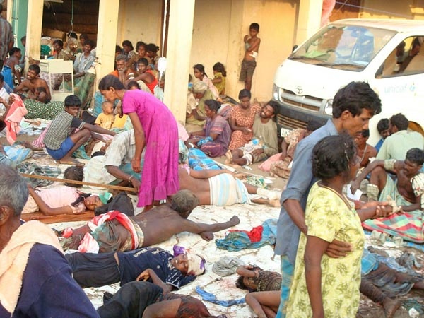 Sri Lankan ethnic Tamil victims of a shell attack wait outside a makeshift hospital in a Tiger controlled No Fire Zone in Mullivaaykaal, Sri Lanka, Sunday, May 10, 2009. (AP Photo)
