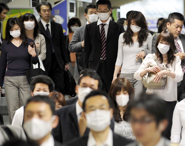 Passengers wear masks as precaution against swine flu at Sannomiya station in Kobe, western Japan, Monday, May 18, 2009. (AP / Kyodo News)