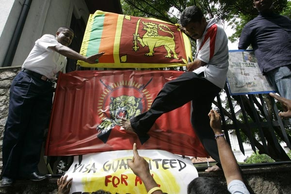 A Sri Lankan protester kicks a Tamil Tiger flag after fixing it to the parapet wall of the Canadian Embassy during a protest in Colombo, Sri Lanka, Wednesday, May 27, 2009.(AP / Eranga Jayawardena)