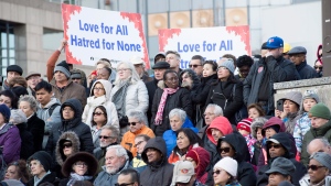 People hold signs and look on at a vigil remembering the victims of Monday's deadly van attack, at Mel Lastman Square in Toronto on Sunday, April 29, 2018. THE CANADIAN PRESS/Frank Gunn