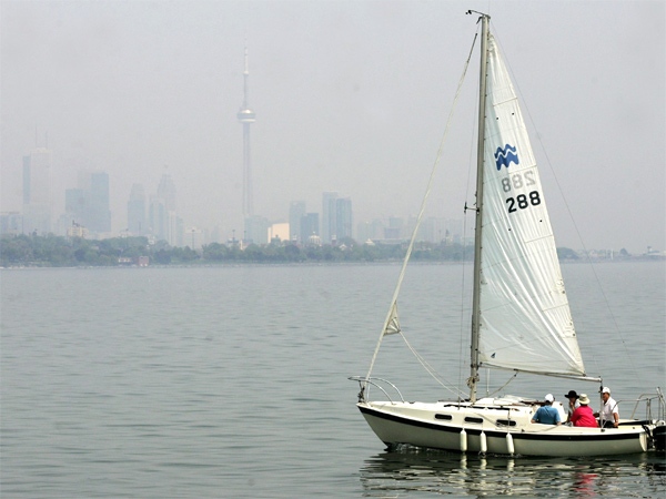 Sailors overlook Toronto's hazy city skyline while out enjoying the above-normal warm weather near Humber Bay Park on May 24, 2007. (CP / Nathan Denette)