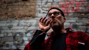 Jimson Bienenstock smokes a joint during a "Wake and Bake" legalized marijuana event in Toronto on Wednesday, October 17, 2018. THE CANADIAN PRESS/Christopher Katsarov