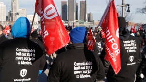 Supporters for Unifor, the national union representing auto workers, attend a rally within view of General Motors headquarters, background, Friday, Jan. 11, 2019, in Windsor, Ont. Workers were protesting the closing of the Oshawa assembly plant, (AP Photo/Carlos Osorio)