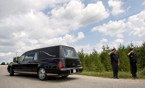 Police officers salute the hearse carrying the remains of a young child found in a remote field near Mount Forest on Monday, July 20, 2009. (THE CANADIAN PRESS/Darren Calabrese)