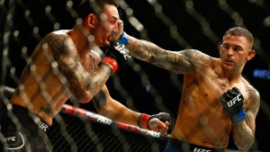 Dustin Poirier, right, punches Max Holloway during an interim lightweight title mixed martial arts bout at UFC 236 in Atlanta, early Sunday, April 14, 2019. (AP Photo/Michael Zarrilli)
