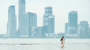A woman paddle boards along Lake Ontario in the extreme heat in Toronto on Friday, July 19, 2019. THE CANADIAN PRESS/Nathan Denette