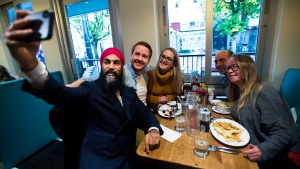 NDP leader Jagmeet Singh poses for a selfie with people in a restaurant in Davie Village during a campaign stop in Vancouver, B.C., on Sunday, October 20, 2019. THE CANADIAN PRESS/Nathan Denette