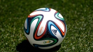 In this May 31, 2014, file photo an official 2014 FIFA World Cup soccer ball lies on the grass during an open practice by the United States in Harrison, N.J.  (AP Photo/Julio Cortez, File)