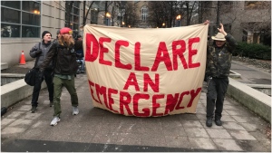 Advocates hold a banner during a past protest that called on the City of Toronto to declare homelessness a state of emergency. 
