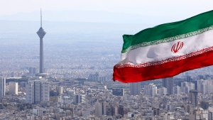 Iran's national flag waves as Milad telecommunications tower and buildings are seen in Tehran, Iran, Tuesday, March 31, 2020. (AP Photo/Vahid Salemi)
