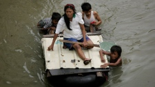 Local residents make their way through floodwaters in Taytay township, Rizal province east of Manila, Philippines, Saturday, Oct. 3, 2009. (AP / Wally Santana)