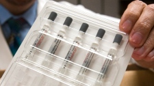 A pharmacy operations coordinator at Methodist Hospital in Omaha, Neb., holds five doses of swine flu vaccine on Monday, Oct. 5, 2009. (AP / Nati Harnik)