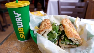 FILE - In this Friday, Feb. 23, 2018 file photo, the Subway logo is seen on a soft drink cup next to a sandwich at a restaurant in Londonderry, N.H. (AP Photo/Charles Krupa, File)