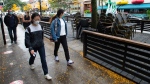 People walk past a closed patio Wednesday, September 30, 2020 in Montreal. The Quebec government has closed all bars and in-room dining as of midnight for the next twenty-eight days.THE CANADIAN PRESS/Ryan Remiorz