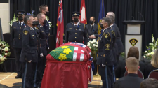 Pallbearers for Const. Marc Hovingh stand at caske