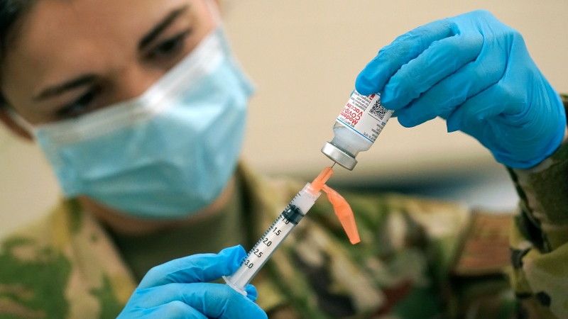 Capt. Brandy Lee with the Mississippi Air National Guard, withdraws a dose of the Moderna COVID-19 vaccine for injection into the arm of a Mississippi Air or Army National Guard service member who serves as a first responder, Wednesday, Dec. 23, 2020, in Flowood, Miss. (AP Photo/Rogelio V. Solis)