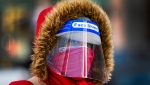 A woman bundles up in the cold weather wearing her PPE during the COVID-19 pandemic in Toronto on Thursday, February 11, 2021. THE CANADIAN PRESS/Nathan Denette