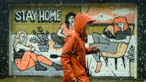 A person walks past a COVID-19 mural designed by artist Emily May Rose on a rainy day during the COVID-19 pandemic in Toronto on Monday, April 12, 2021. THE CANADIAN PRESS/Nathan Denette