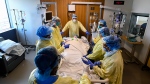 Health-care staff get ready to prone a 47-year-old woman who has COVID-19 and is intubated on a ventilator in the intensive care unit at the Humber River Hospital during the COVID-19 pandemic in Toronto on Tuesday, April 13, 2021. THE CANADIAN PRESS/Nathan Denette