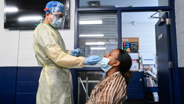A health-care worker tests a woman at a pop-up COVID-19 assessment centre at the Angela James Arena during the COVID-19 pandemic in Toronto May 19, 2021. THE CANADIAN PRESS/Nathan Denette