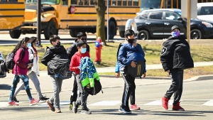 FILE - Students cross the street at Tomken Road Middle School during the COVID-19 pandemic in Mississauga, Ont., on Thursday, April 1, 2021. THE CANADIAN PRESS/Nathan Denette 