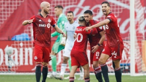 Toronto FC midfielder Marco Delgado (8) celebrates his goal with teammates Yeferson Soteldo (30), Michael Bradley (4) and Omar Gonzalez (44) during first half MLS soccer action against the Chicago Fire, in Toronto, Sunday, Oct. 3, 2021. (Cole Burston/The Canadian Press via AP)