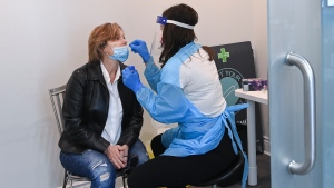 Lucilia Pato, left, 62, receives a COVID-19 test after getting her Oxford-AstraZeneca COVID-19 vaccine from pharmacist Barbara Violo, at the Junction Chemist which is a independent pharmacy during the COVID-19 pandemic in Toronto on Friday, March 12, 2021. THE CANADIAN PRESS/Nathan Denette