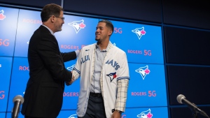 Ross Atkins, executive vice president of baseball operations and general Manager of The Toronto Blue Jays, left, shakes hands with starter José Berríos during a press conference announcing his seven-year extension with the team at the Rogers Centre in Toronto on Thursday, November 18, 2021. THE CANADIAN PRESS/Tijana Martin