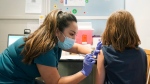 Courtney Martin, left, a nurse at the University of Washington Medical Center, gives the first shot of the Pfizer COVID-19 vaccine to Ani Hahn, 7, Tuesday, Nov. 9, 2021, in Seattle. (AP Photo/Ted S. Warren) 