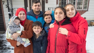The Darrouba family, Hadi, left to right, Nadia, her husband Zoheir, Akram, Mostafa, Israa and Aya pose for a portrait in front of their home in Peterborough, Ont., Sunday, Dec. 5, 2021. The family members are among nearly 46,000 Syrian refugees resettled in Canada by April 2017 under a program introduced by the Liberal government in 2015 to make it much easier for Syrian refugees to reach Canada. THE CANADIAN PRESS/Fred Thornhill