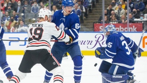 Toronto Maple Leafs goaltender Petr Mrazek makes a save as Maple Leafs' David Kampf (centre) holds off Chicago Blackhawks' Jonathan Toews during first period NHL hockey action in Toronto, on Saturday, December 11, 2021. THE CANADIAN PRESS/Chris Young