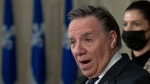 Quebec Premier Francois Legault speaks at a news conference marking the end of the fall session, Friday, December 10, 2021 at his office in Quebec City. Deputy premier and Public Security Minister Genevieve Guilbault, behind, looks on. THE CANADIAN PRESS/Jacques Boissinot 